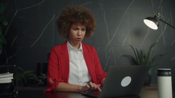 Bizneswoman Czerwonej Kurtce Wyglądająca Zdezorientowaną Podczas Pracy Laptopie Prawdopodobnie Zajmująca — Wideo stockowe