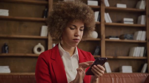 Profesjonalna Kobieta Czerwonej Marynarce Zastanawia Się Trzymając Telefon Komórkowy — Wideo stockowe