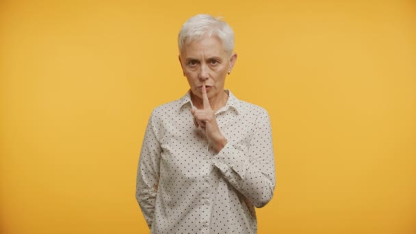 Зріла Жінка Коротким Білим Волоссям Тримає Палець Губах Тихого Жовтому — стокове відео