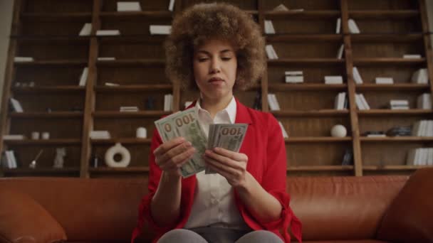 オフィスの米ドル紙幣を数える赤いスーツに焦点を当てた女性 — ストック動画