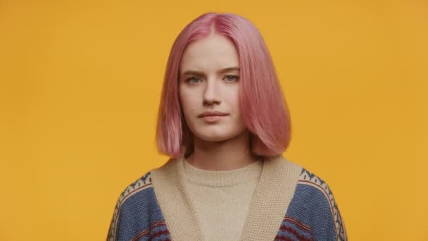 Młoda Kobieta Uderzającymi Różowymi Włosami Bez Wyrazu Twarzy Żółtym Tle — Wideo stockowe