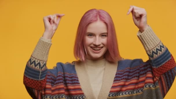 Pembe Saçlı Gülümseyen Hareketleriyle Sarı Arka Planda Dans Eden Genç — Stok video