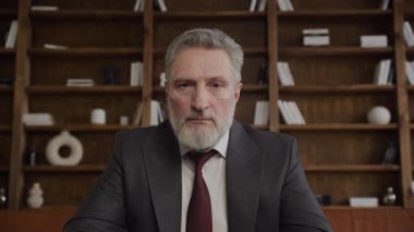 Onurlu kıdemli bir işadamının portresi. İyi döşenmiş bir ofiste, deri bir koltukta oturuyordu.