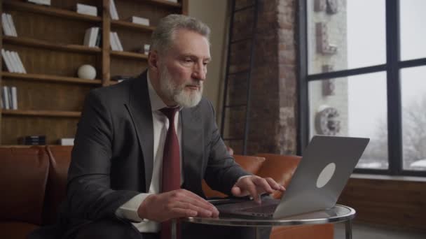 Focused Senior Businessman Browsing Laptop Chic Loft Office Space Natural — Stock Video