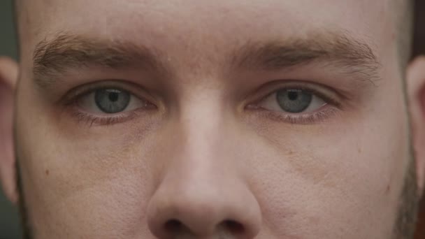 マクロは若者の激しい視線を撮影し 彼の明確な青い目と自然な顔の詳細を強調し ゆっくりとした動きで目を開く — ストック動画