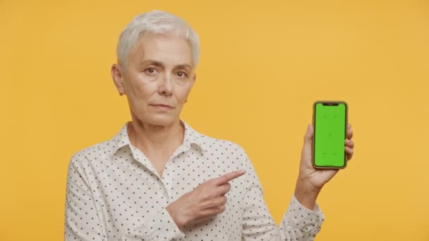 Mujer Anciana Con Pelo Gris Apuntando Smartphone Con Una Pantalla — Vídeo de stock