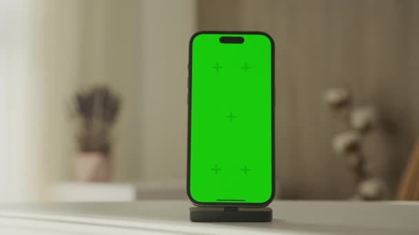 智能手机在一个模糊的内部背景下充电 显示一个可定制的绿色彩色按键屏幕 — 图库视频影像