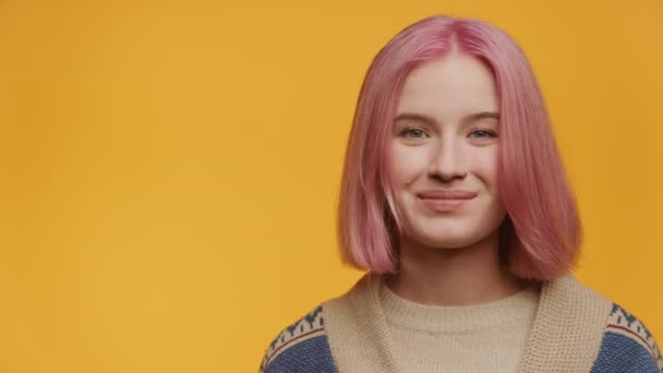 黄色の背景 左側のコピースペースでモダンで陽気なピンク髪の若い女性を笑顔にする — ストック動画