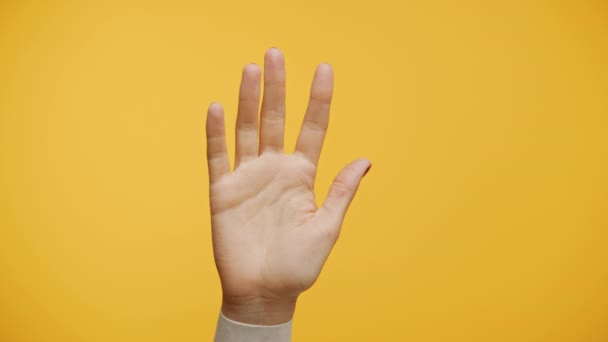 Χέρι Κυματίζει Στο Κίτρινο Φόντο Γεια Χειρονομία — Αρχείο Βίντεο