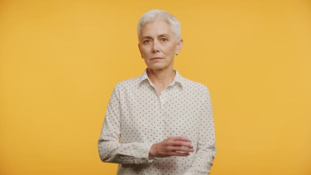 短い白髪とポルカドットシャツ 腕を折った 深刻な表現を持つ高齢女性 — ストック動画