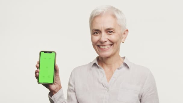Feliz Anciana Presentando Smartphone Con Pantalla Verde Listo Para Promoción — Vídeo de stock