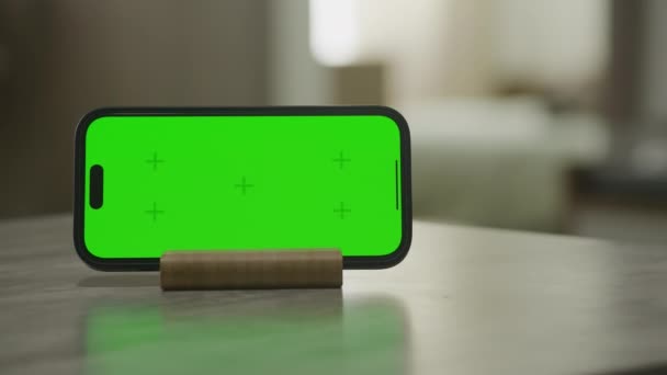 在水平智能手机周围的轨道上 木制支架上有一个绿色的彩色键屏幕 内部背景模糊不清 — 图库视频影像
