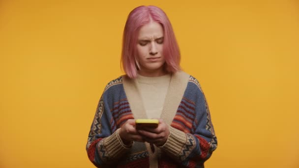 Młoda Osoba Różowymi Włosami Zakłopotanym Wyrazem Twarzy Patrząca Kamerę Przeczytaniu — Wideo stockowe