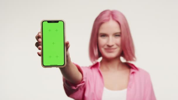 Mujer Joven Con Pelo Rosa Que Presenta Smartphone Con Pantalla — Vídeo de stock