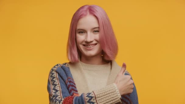 Fröhliche Junge Frau Mit Rosa Haaren Gibt Vor Gelbem Hintergrund — Stockvideo