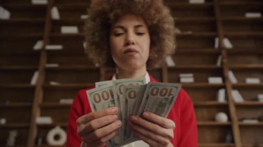 Banknotları tutan ve inceleyen kendine güvenen bir iş kadını.