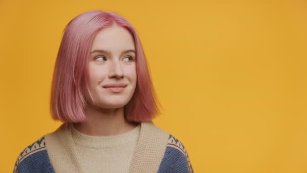 コピースペースを見てピンクの髪の女性と黄色の背景に対してノッディングヘッド — ストック動画