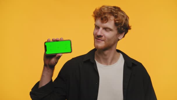 Homem Cabelo Gengibre Sorrindo Admirando Smartphone Com Uma Tela Tecla — Vídeo de Stock