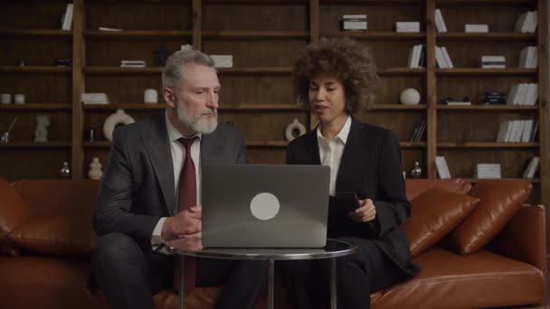 Два Бизнес Профессионала Обсуждают Варианты Недвижимости Ноутбуком Стильной Офисной Обстановке — стоковое видео