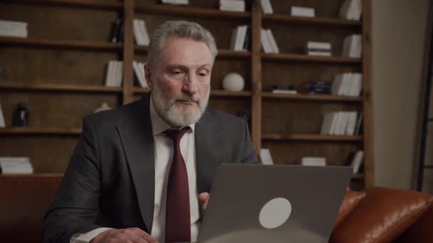 Dojrzały Biznesmen Rozmowie Przez Laptopa Wyrafinowanym Ustawieniu Biurowym — Wideo stockowe