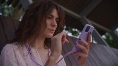 Açık havada akıllı telefon kullanan yoğun odaklı bir kadın.