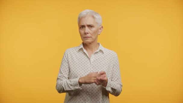 Starší Žena Ukazuje Zápěstí Nepohodlí Proti Žluté Pozadí — Stock video