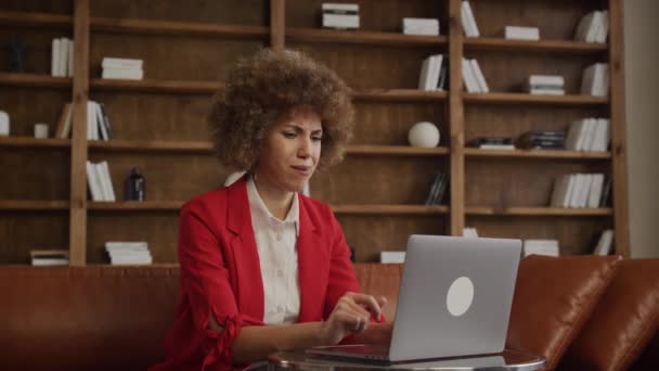 赤いブレーザーの熟練した若い女性はストレスを感じ 額に触れ 机の上のラップトップ — ストック動画