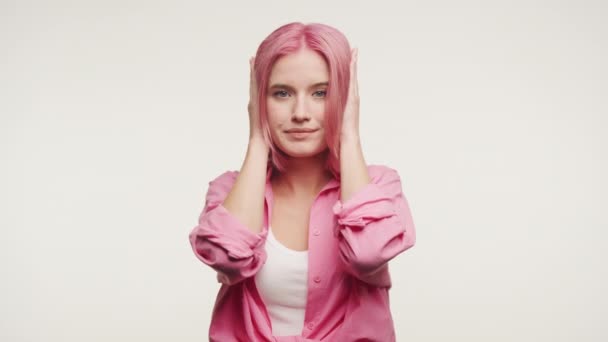 Спокойная Молодая Женщина Закрывающая Уши Розовые Волосы Обрамленные Скептическим Выражением — стоковое видео