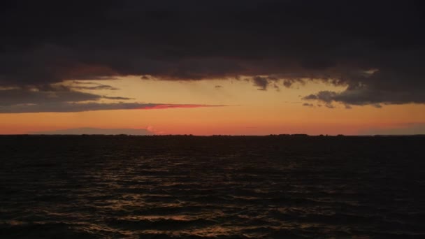 在乌云的映衬下 夕阳西下 映照在波涛汹涌的海面上 — 图库视频影像
