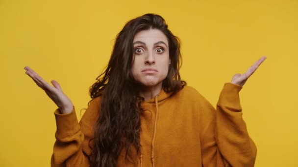 Kobieta Zakłopotanym Wyrazem Twarzy Wzruszająca Ramionami Żółtym Tle — Wideo stockowe