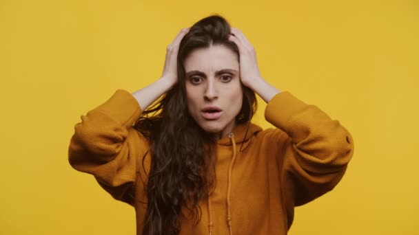 Schockierte Frau Orangefarbenem Kapuzenpulli Hält Ihren Kopf Und Drückt Ihre — Stockvideo