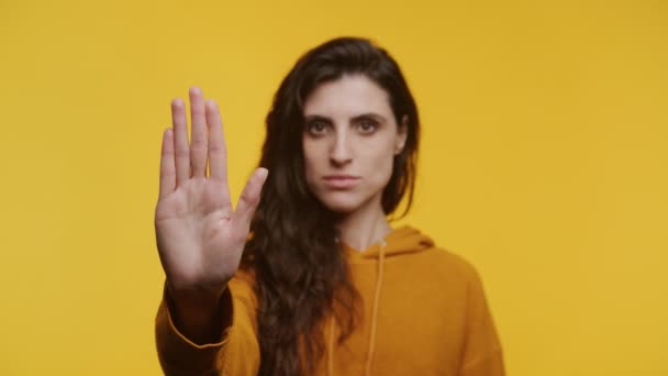 Serious Woman Mustard Hoodie Giving Stop Hand Sign Yellow Background — Stock Video