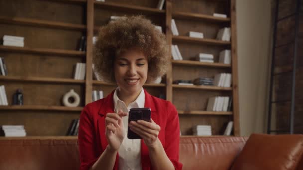 スマートフォンでオフィスの設定で笑顔の女性 — ストック動画