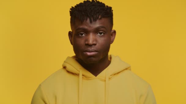 Junger Mann Gelbem Kapuzenpullover Steht Vor Gelbem Hintergrund Und Wirkt — Stockvideo