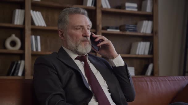 Ώριμος Επιχειρηματίας Μιλάει Στο Τηλέφωνο Κάθεται Φόντο Γραφείο — Αρχείο Βίντεο