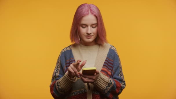 Una Joven Reflexiva Sosteniendo Smartphone Aislado Sobre Fondo Amarillo — Vídeos de Stock