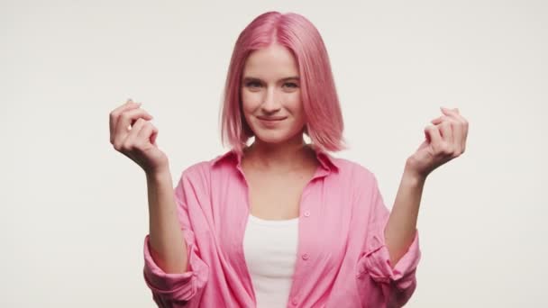 白い背景にピンクの髪のお金のジェスチャーと陽気な女性 — ストック動画