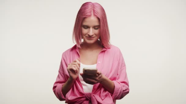 Mulher Alegre Com Cabelo Rosa Aparelho Usando Telefone Celular Isolado — Vídeo de Stock