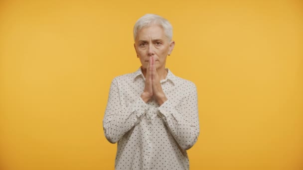 Elleri Sarı Arka Planda Dua Eden Olgun Bir Bayan — Stok video