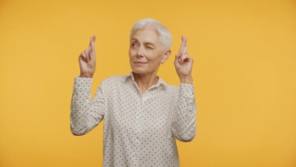 Elderly Lady Closed Eyes Crossing Fingers Hope Isolated Yellow Background — Stock Video