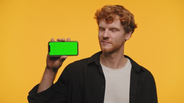 Радостный Мужчина Смартфоном Показывающим Зеленый Экран Рядом Знаком Ярком Желтом — стоковое видео