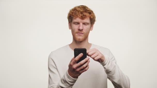 Ginger Man Browsing Smartphone Knikken Head Approval Gesture Geïsoleerd Witte — Stockvideo