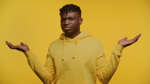 Mann Gelben Kapuzenpullover Mit Ratlosem Gesichtsausdruck Hände Unsicherheit Erhoben Isoliert — Stockvideo