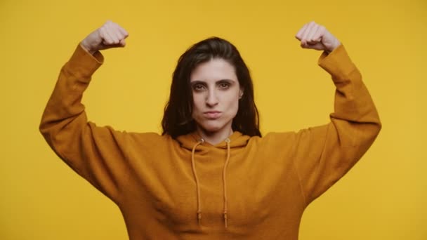 Jonge Vrouw Flexing Biceps Speelse Pruik Mosterd Hoodie Effen Gele — Stockvideo