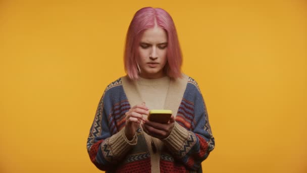 Junge Frau Mit Pinkfarbenen Haaren Schaut Schockiert Auf Ihr Smartphone — Stockvideo