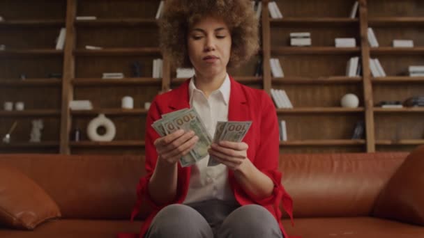 レザーソファに座ったお金を数える女性起業家 — ストック動画