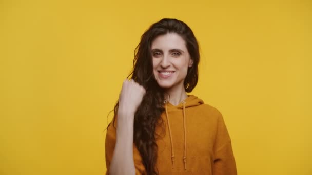 Cheerful Woman Fist Pumping Ochre Hoodie Celebrating Achievement Yellow Background — Stock Video