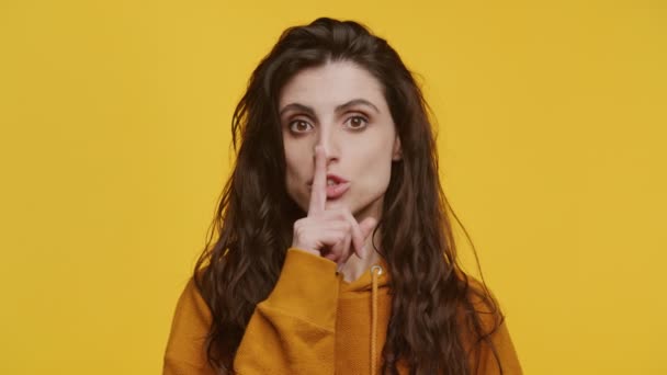 Νεαρή Γυναίκα Χειρονομεί Ήσυχο Σημάδι Δάχτυλο Στα Χείλη Απομονώνονται Κίτρινο — Αρχείο Βίντεο