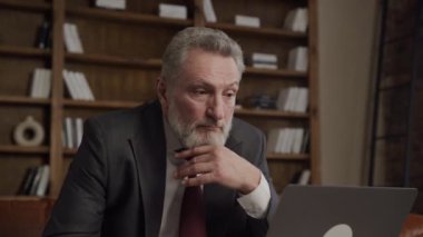 Olgun erkek yönetici, ofiste dizüstü bilgisayarla başarısını ifade ediyor.