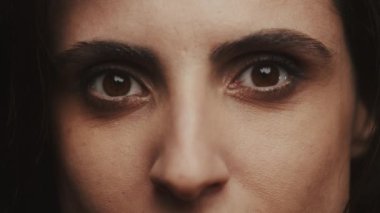 Çekici kahverengi gözlü bir kadının yoğun bakışlarına odaklanan yakın plan portre.